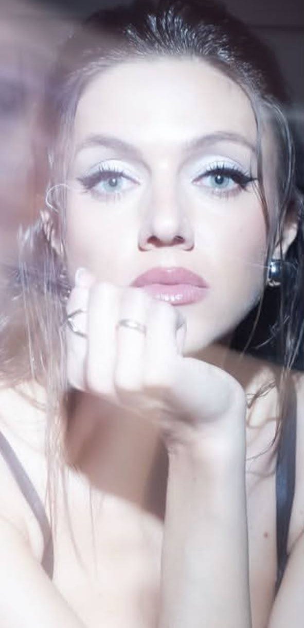 Close-up of an evening look: pearl-white shimmer on the lid, graphic liner, glossy nude lip.